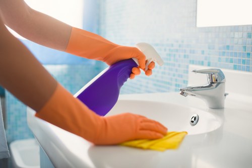 Cleaner wiping lift buttons and shared surfaces in a W1W block